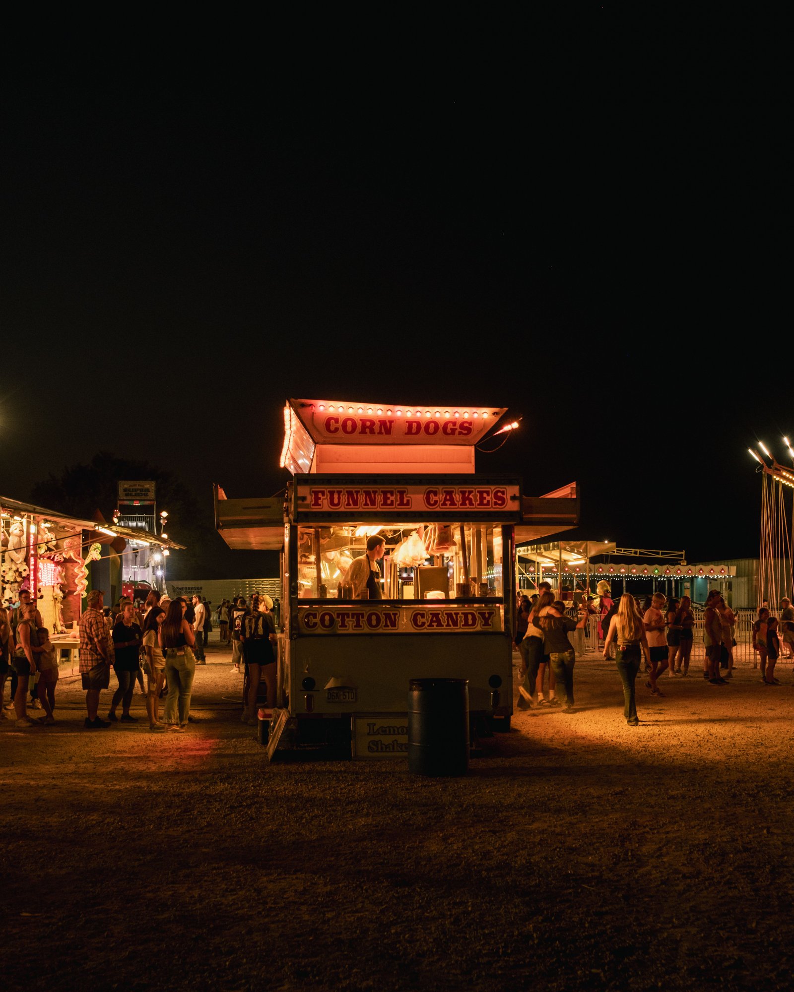 A festival food stand lit up at night